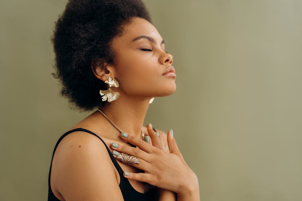 Close-up of a woman with afro hair meditating, eyes closed, embracing wellness and mindfulness.