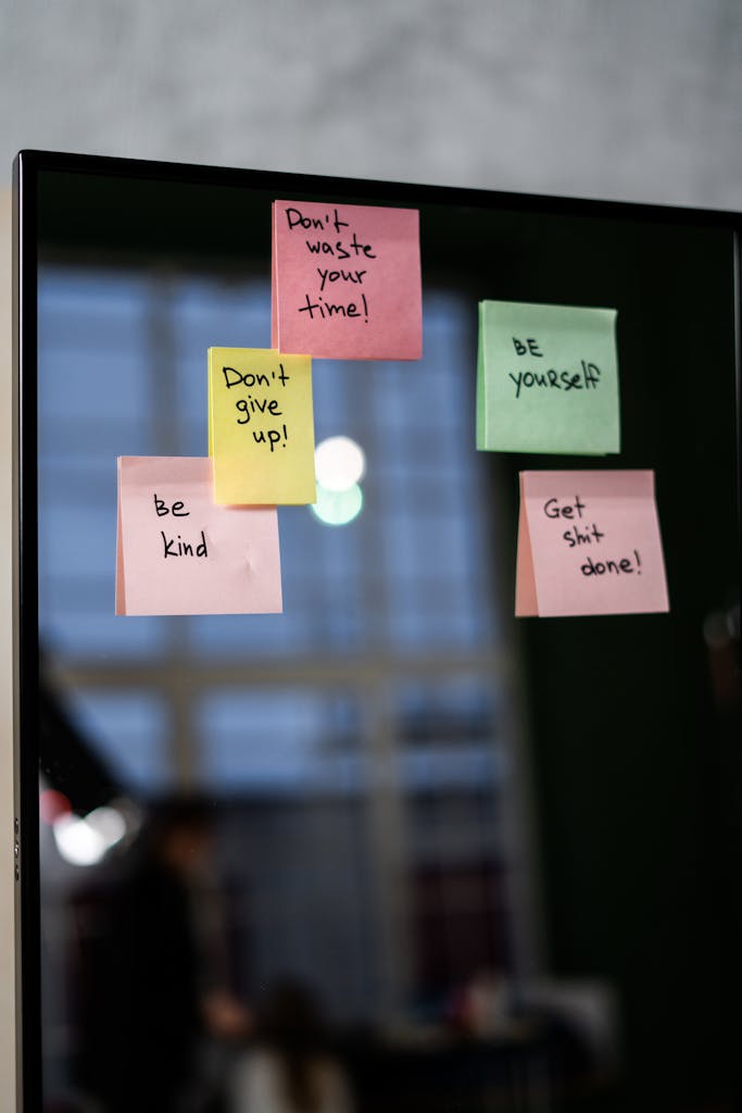 Colorful sticky notes with motivational quotes on a mirror indoors.