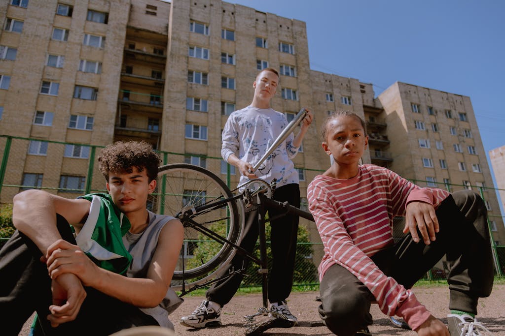 Teen boys hanging out with a bicycle in an urban area, fostering friendship.