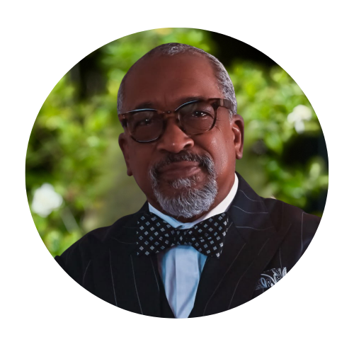 | Fuller Life Family Therapy Portrait of a man in a pinstripe suit, blue shirt, polka-dot bow tie, and glasses outdoors.
